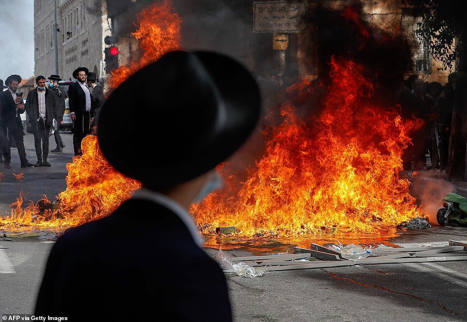 38508762-9189371-Hundreds_of_ultra_Orthodox_Jews_clashed_with_riot_police_during_-a-85_1611690149521